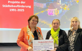 Staatssekretärin Bartmann übergibt einen Scheck Vertreterinnen der Stadt Forst (Foto: Stadt Forst Lausitz / Susanne Joel)